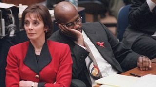 LOS ANGELES, UNITED STATES:Prosecutors Marcia Clark (L) and Christopher Darden (R) listen to defense lawyer Johnnie Cochran Jr. 27 September while he addresses the jury during closing argumen