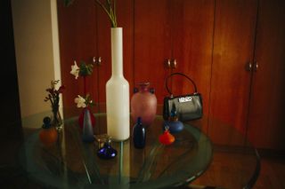 Behind the scenes image: still life with Kenzo black bag and vases