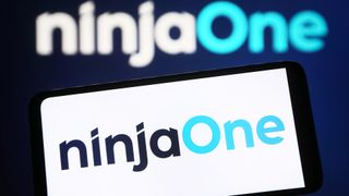 NinjaOne logo and branding pictured on a smartphone with company logo also pictured in background in white and light blue coloring.