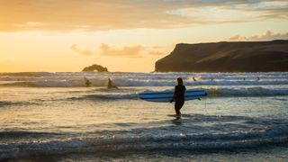 A surfer on the beach at Polzeath