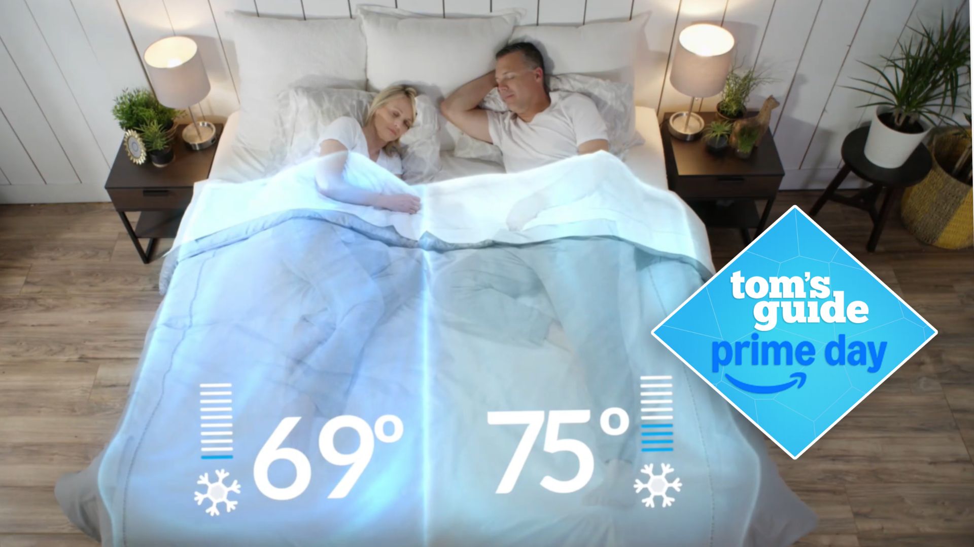 Couple in bed with white sheets and BedJet cooling system next to bedside tables with lamp and plants with Tom&#039;s Guide