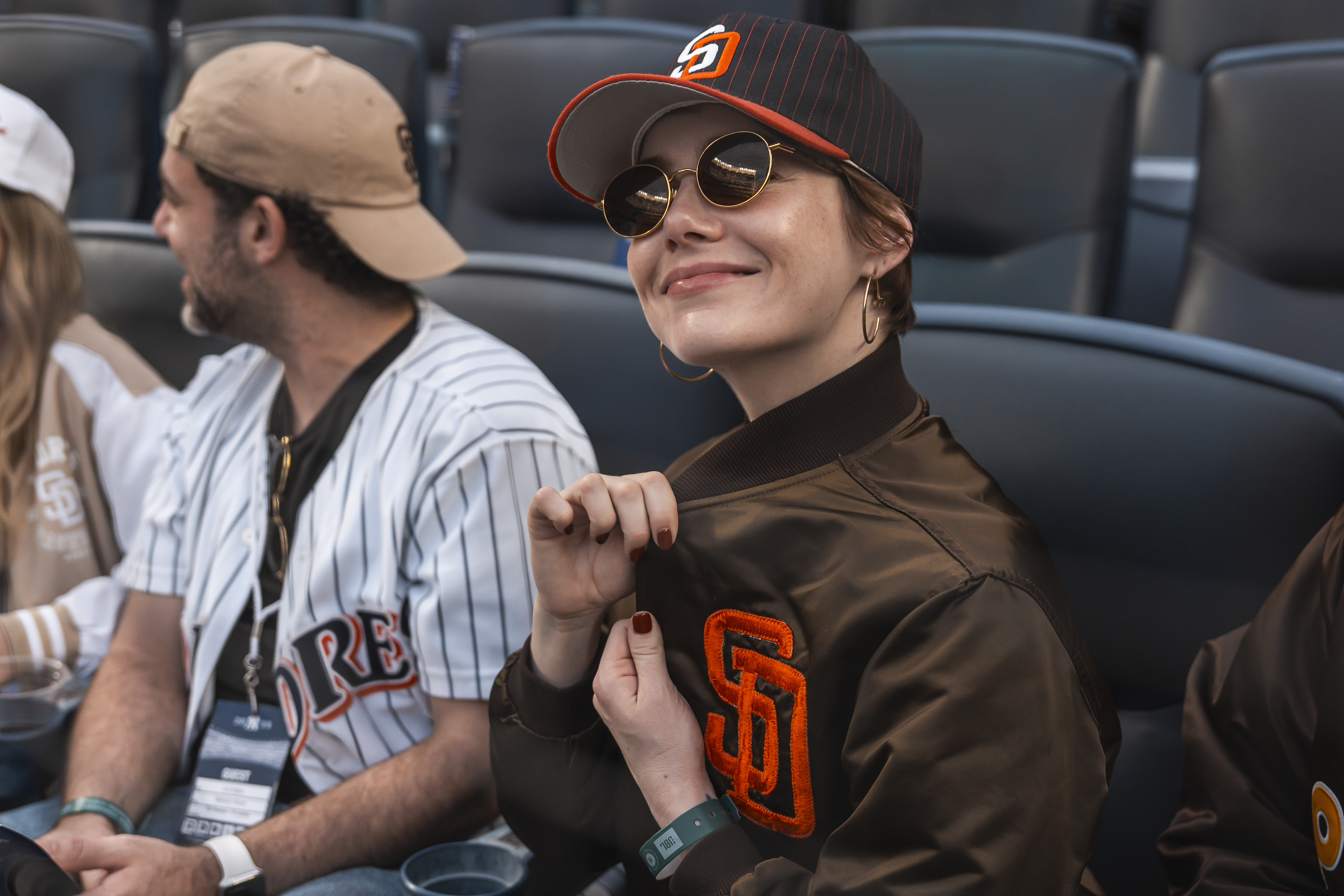 Emma Stone showing off her red manicure and brown bomber jacket.