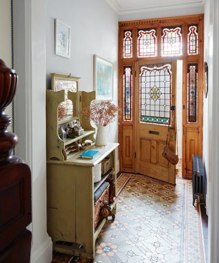 Victorian hallway tiles in an entryway with authentic period stained glass door