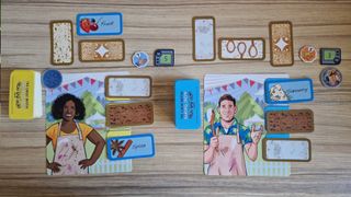 The Great British Baking Show Game pieces laid out on a wooden table