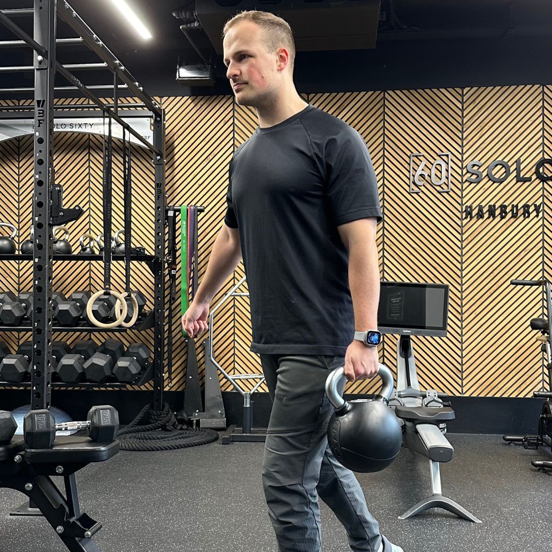 Personal trainer Ollie Thompson demonstrating a suitcase carry