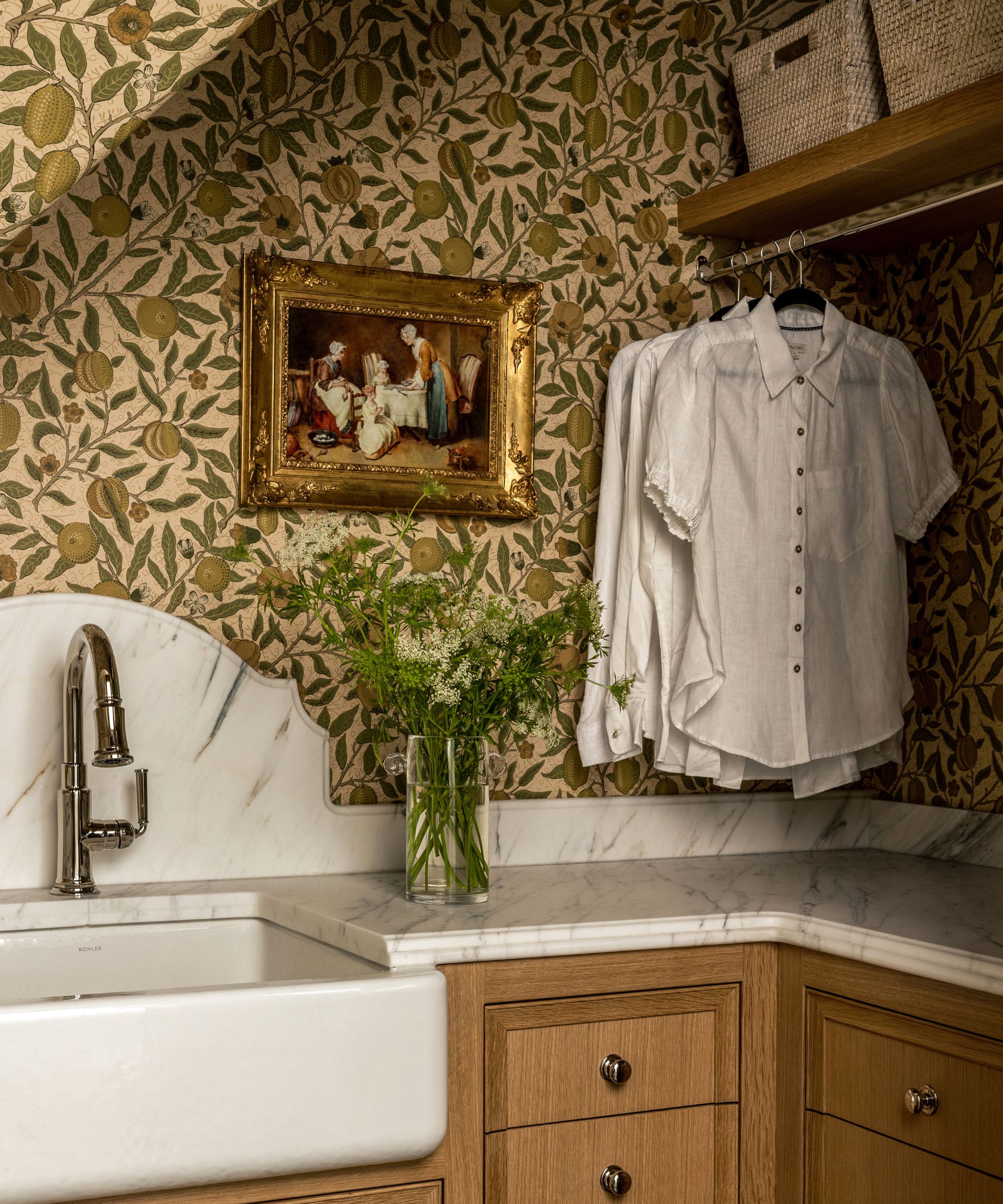 small attic laundry room with William Morris wallpaper, marble worktop and a clothes hanging rail