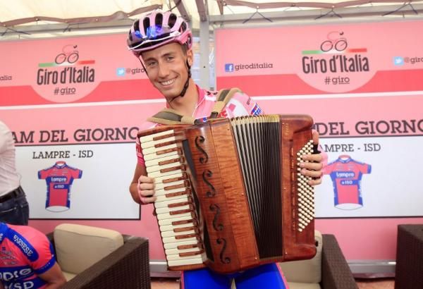 The multi-talented Adriano Malori plays the accordion while resplendent in the maglia rosa.