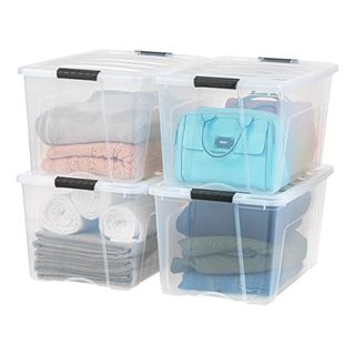 Clear 72 Qt Stackable Plastic Storage Bins With Lids. Four arranged two by two filled with folded towels, clothing and handbags