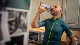 Image shows a rider drinking a protein-packed recovery drink.