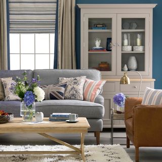 living room with blue wall and grey sofa cushion