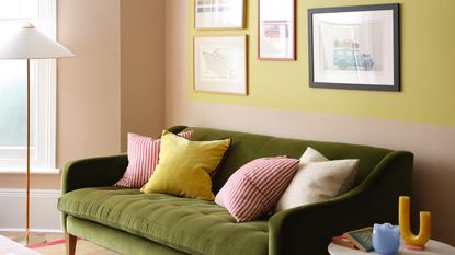 A living room with a green velvet sofa painted in Benjamin Moore&#039;s Yellow Tone 370 and Terra Bella AF-195