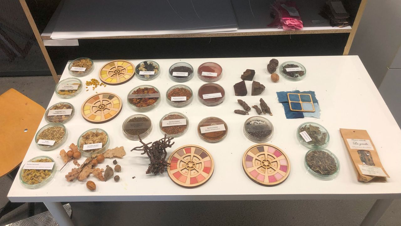 A table laid out with various fabrics and substances that made the clothing.