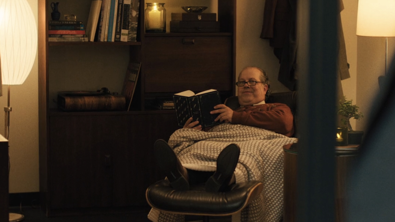 HR rep sitting in recliner reading a book in The Chair Company Season 1