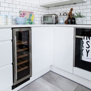 white kitchen cabinet and white counter top with toaster