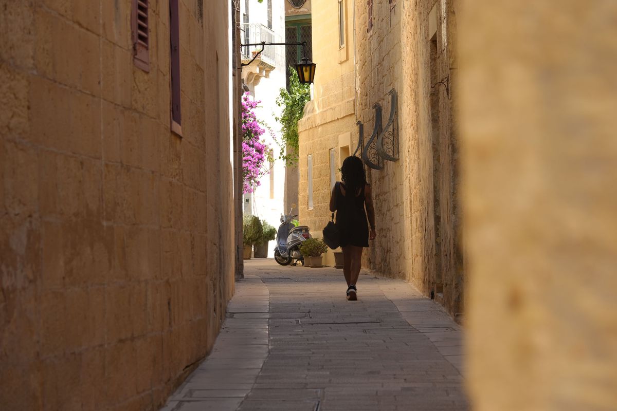 Sony RX10 V bridge camera sample gallery, woman walking down an ancient street in Malta