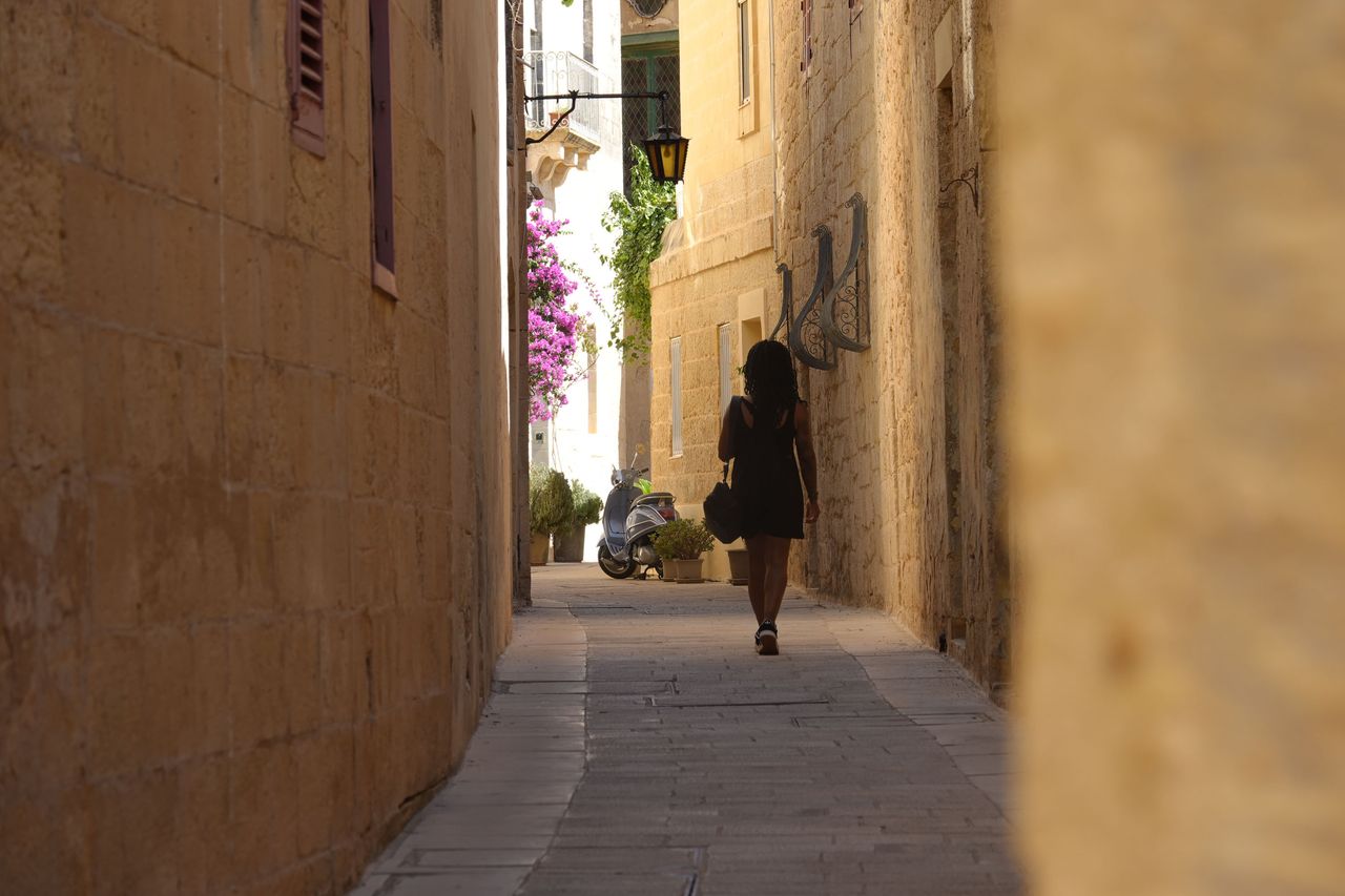 Sony RX10 V bridge camera sample gallery, woman walking down an ancient street in Malta