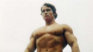 Arnold Schwarzenegger posing shirtless outdoors