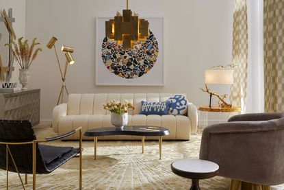 Jonathan Adler shows how to plan living room lighting, with cream sofa and statement gold pendant light.