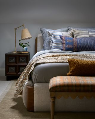 A bedroom with lots of pillows and a blanket