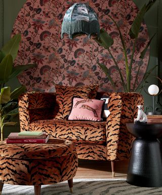 A bold living room with wallpaper and paint decor, and animal print sofa with matching footstool