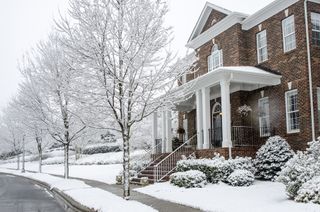 A traditional, brick home during a Winter snow storm