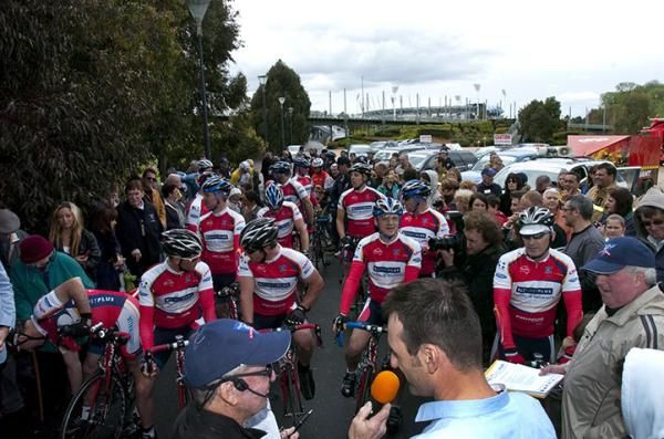 Members of the Melbourne Fire Brigade await the start to their ride around Australia in Melbourne with the finishing point, the MCG, in the background.