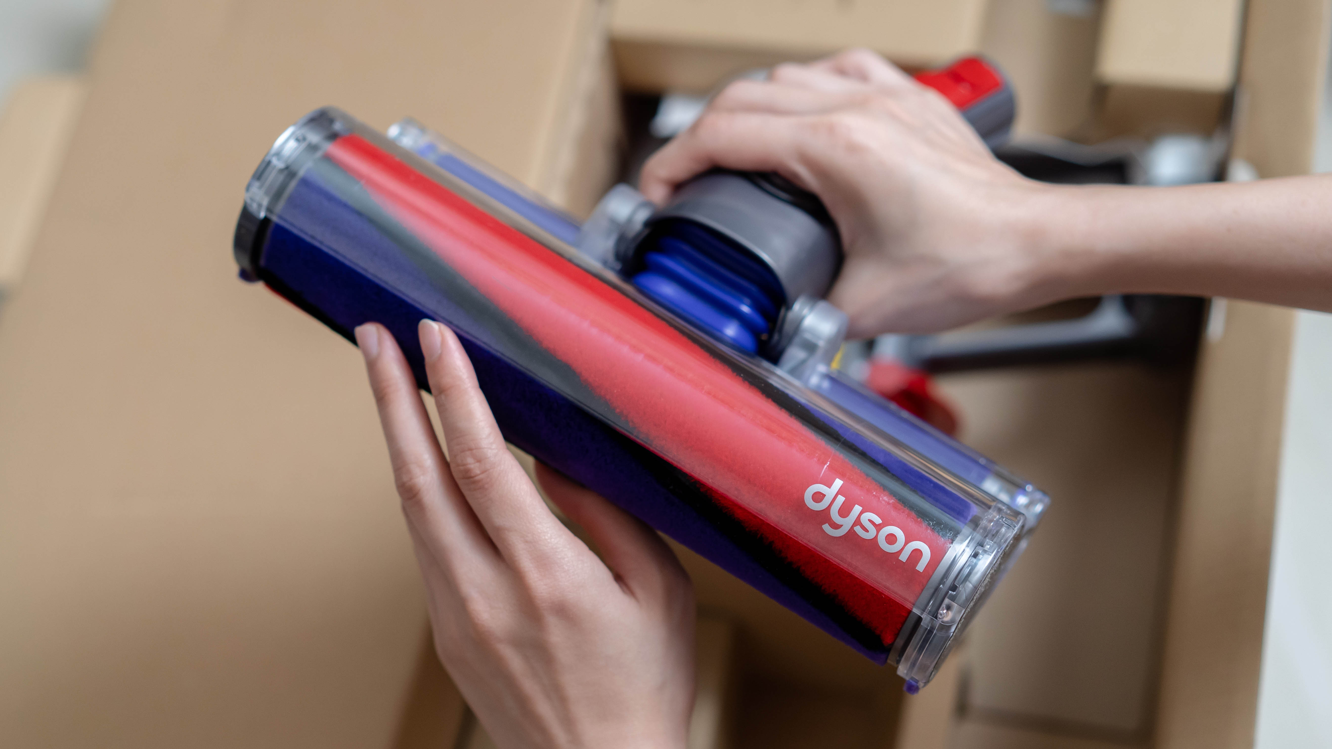 Пылесос Dyson вынимают из коробки.