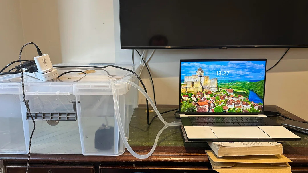 Razer Blade 16 with giant cooler attached, the cooler is made from a plastic storage crate