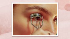 A close up of a woman's eye and eyebrow as she curls her eyelashes with an eyelash curler/ in a pink textured watercolour-style template