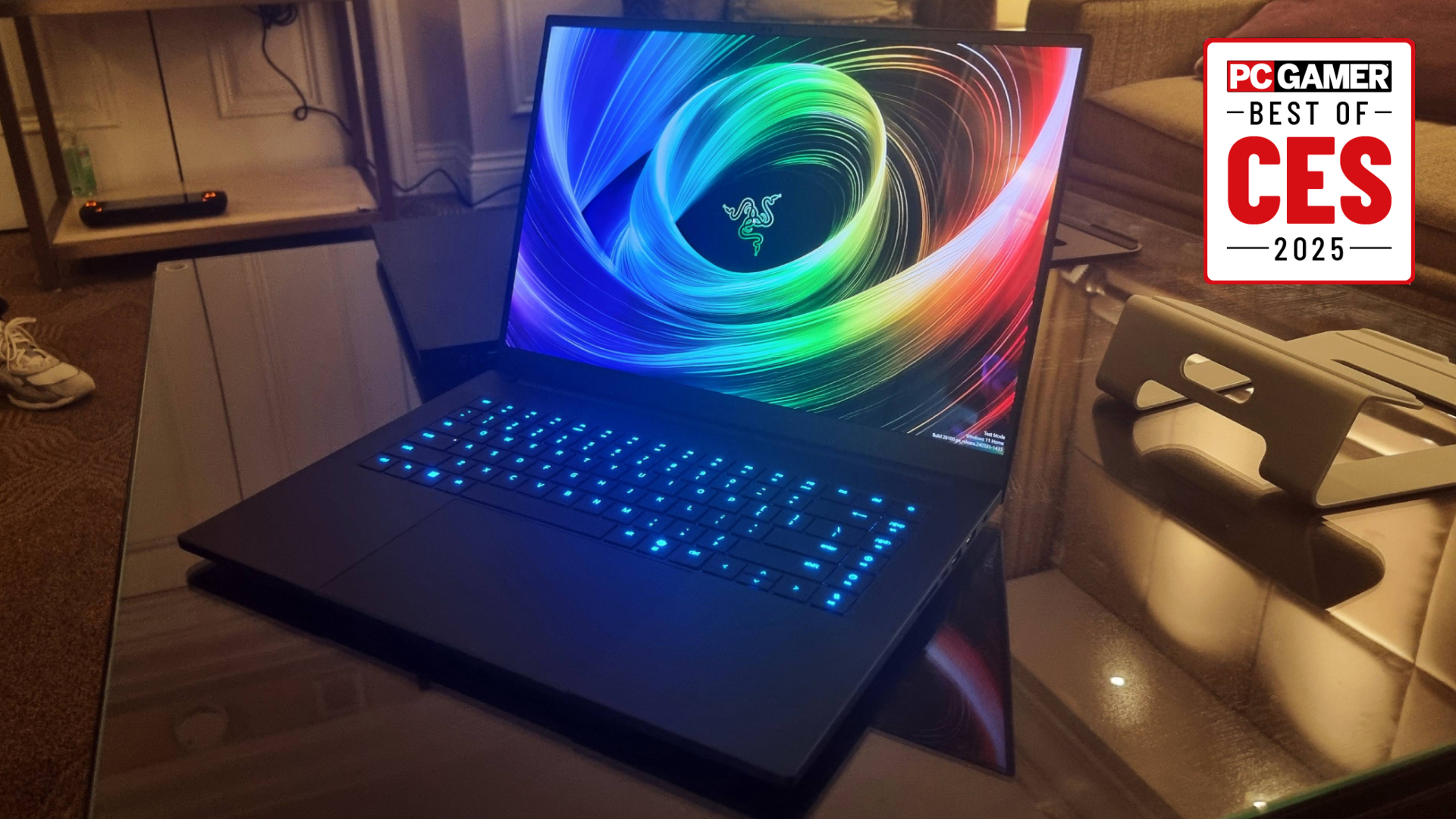 The Razer Blade 16 on a glass table at CES 2025, with the PC Gamer Best of CES 2025 logo in the top right.