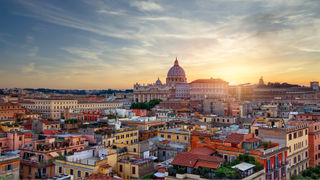 Sunset over the Papal Basilica of Saint Peter and the city buildings in Rome