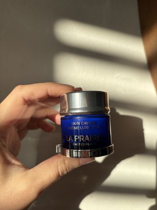 Mica Ricketts holding pot of La Prairie Skin Caviar Luxe Eye Cream