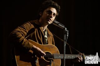 Timothée Chalamet, in a scene from the forthcoming film, A Complete Unknown. Chalamet is playing one of two Gibson J-50 models made specifically for the film