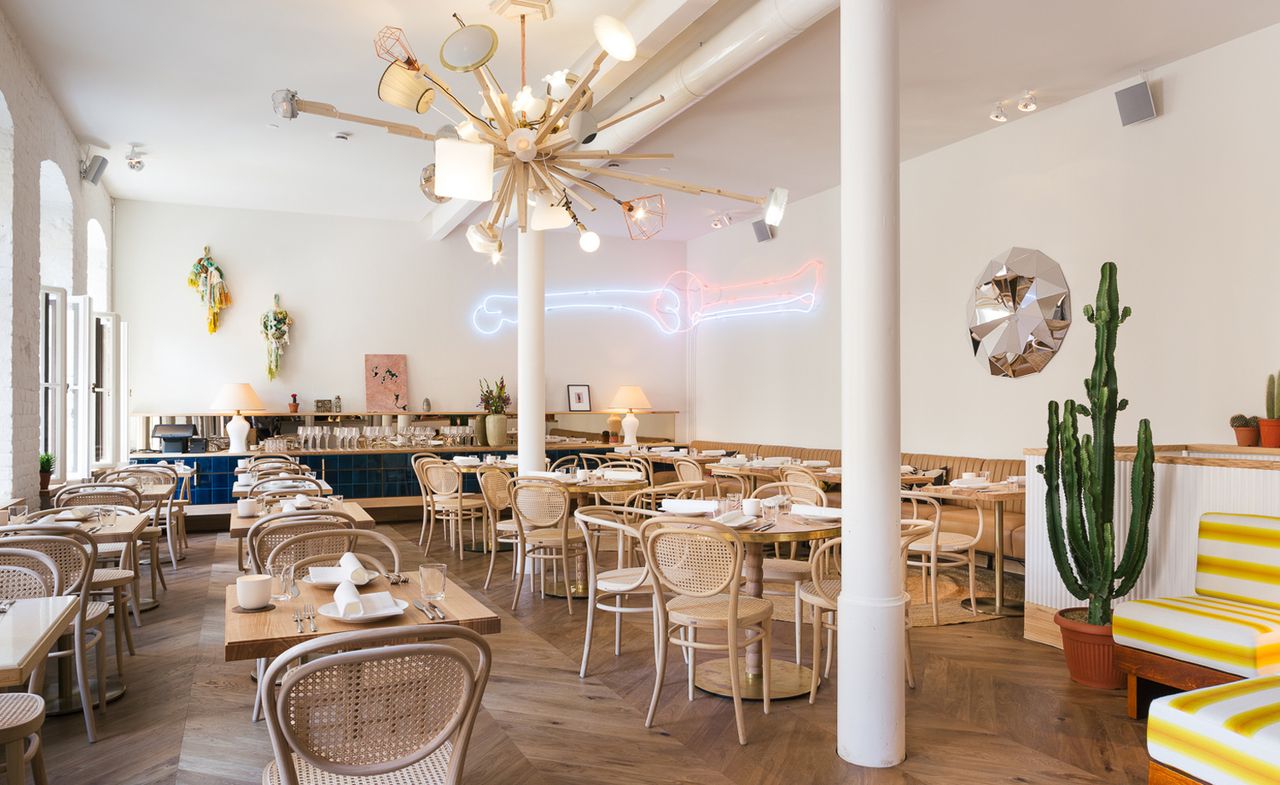 Dining room featuring natural wood, parquet flooring and an abstract light fixture