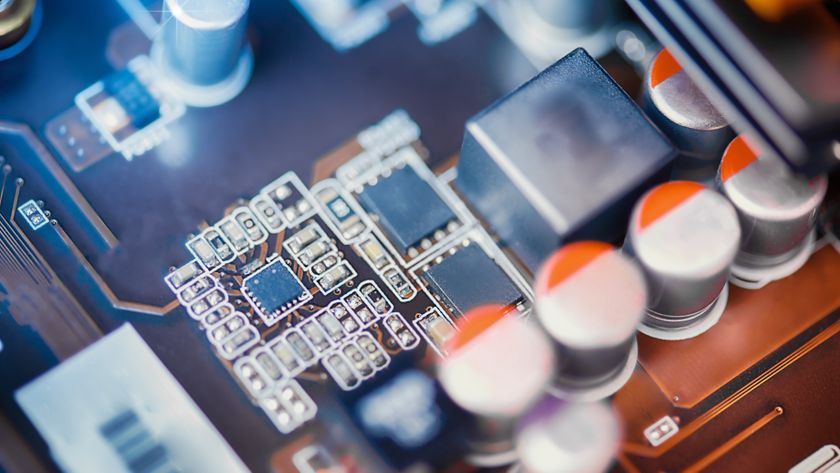 A circuit board with visible transistors and capacitors, artfully and tastefully lit with blue and orange lighting.