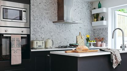 Marble kitchen island with wooden bar stools, wall art, light fixtures