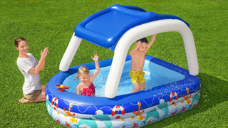 Image of kids in an inflatable pool with mom sitting nearby
