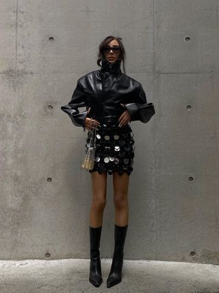 woman wearing sequin mini skirt with mid-calf boots and leather jacket