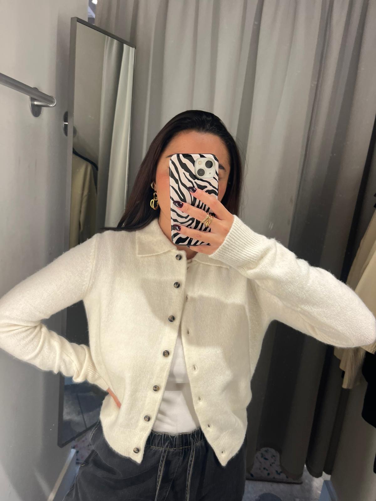 Marina wearing white cardigan