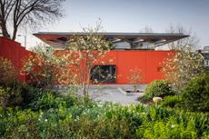 Maggie's West London, an orange structure and its mature garden