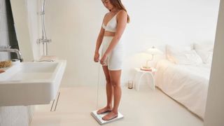 Lady stood on a Withings Body Scan