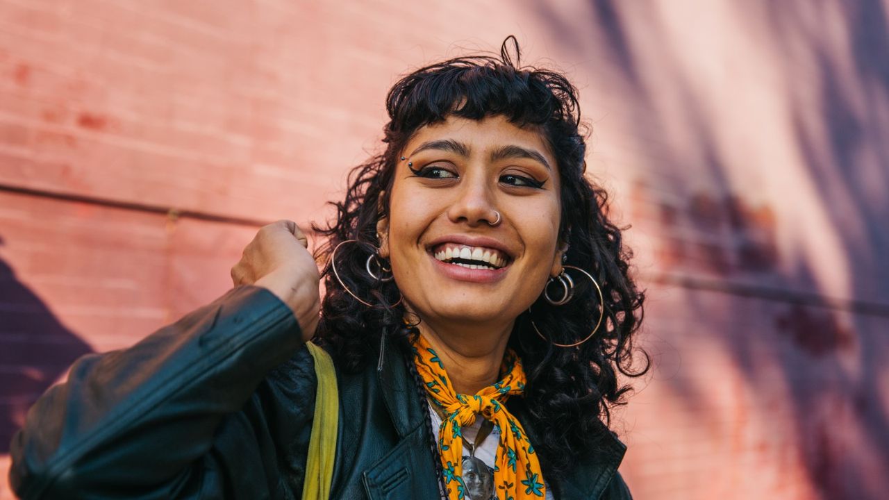 Young confident woman smiling, wearing fringe hairstyles - stock photo