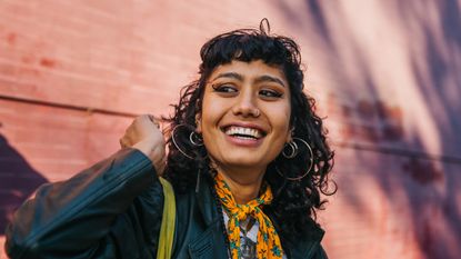 Young confident woman smiling, wearing fringe hairstyles - stock photo