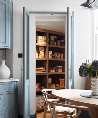 corner walk in pantry idea with blue doors and built in shelving