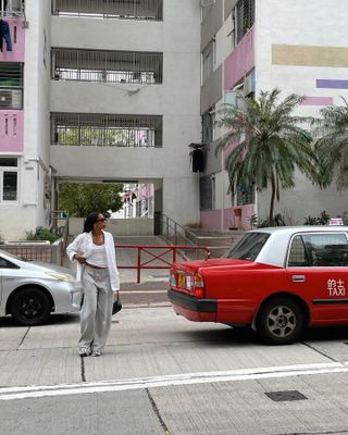 Woman wearing a summer travel outfit of gray sweatpants and a white shirt.