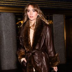 Suki Waterhouse wears a fur trim coat.