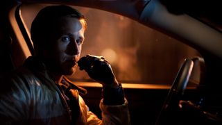 A still from the movie Drive, one of the best free movies to stream, of Ryan Gosling sat in a car looking pensive