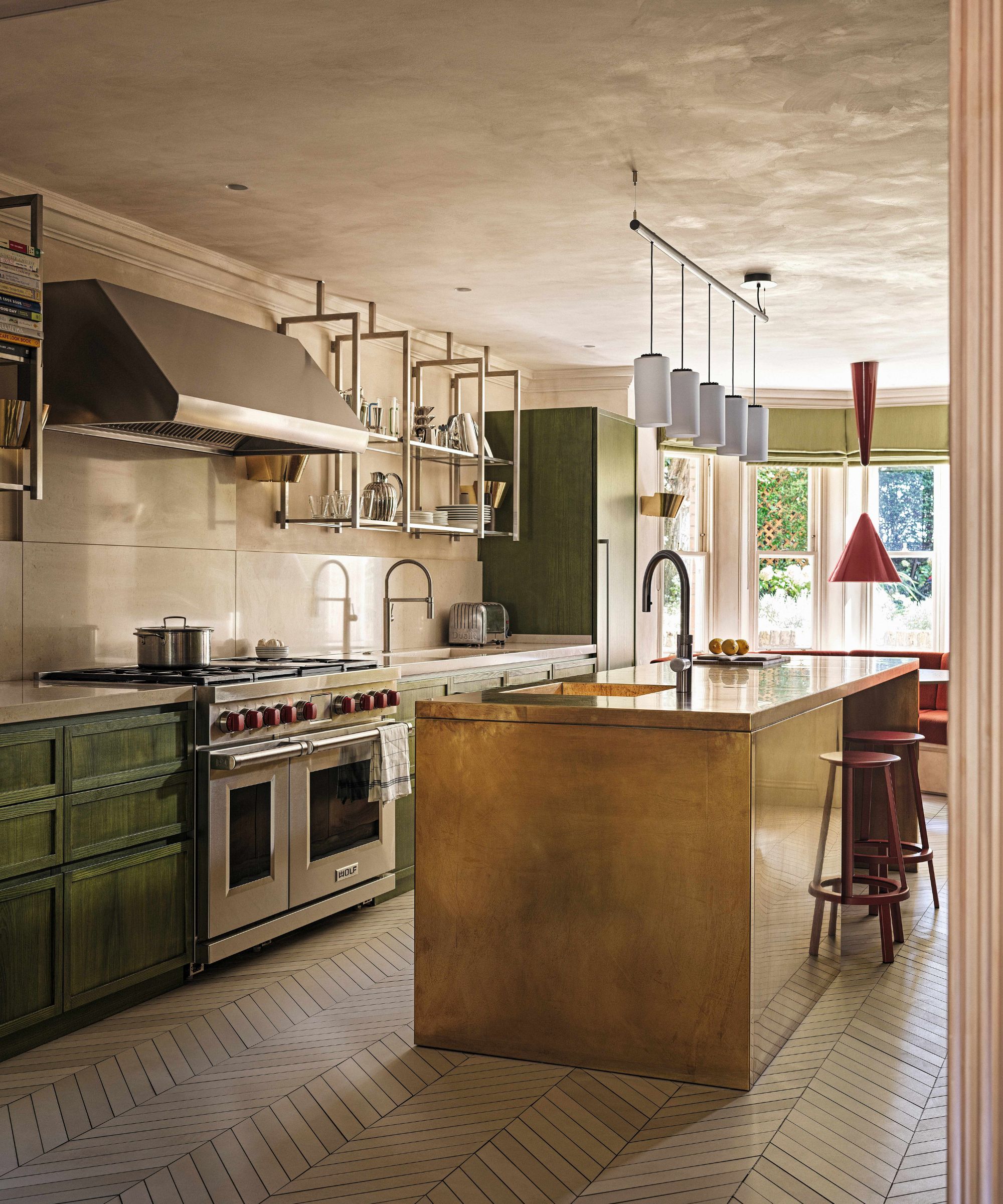 a plaster finished kitchen with green wooden cabinetry and a brass kitchen island