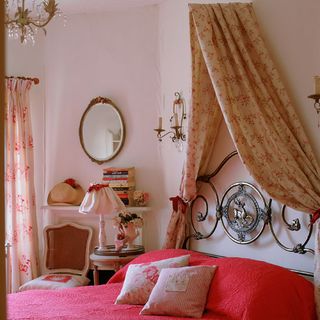 bedroom with pink wall and bed with red bedding