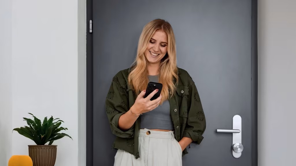 Woman using smartphone to control Nuki Smart Lock Pro